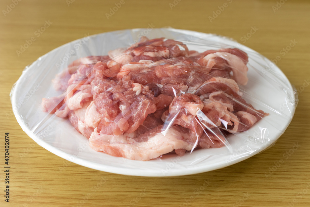 皿にのせてラップをかけた豚肉