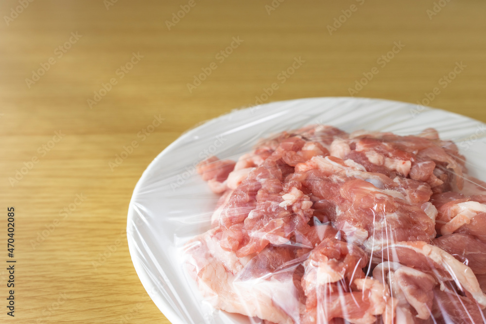 皿にのせてラップをかけた豚肉