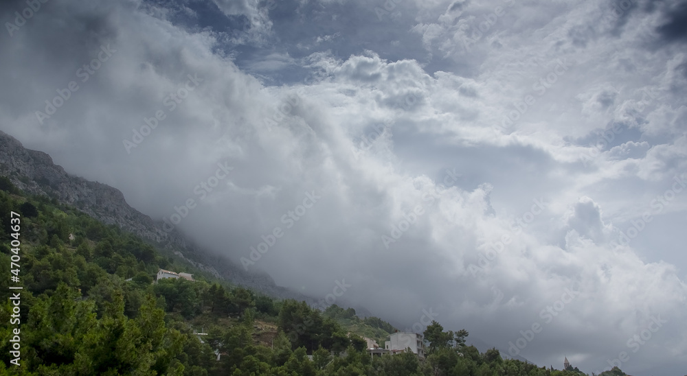 Stok górski z zabudowaniami burzowe chmury zza gór