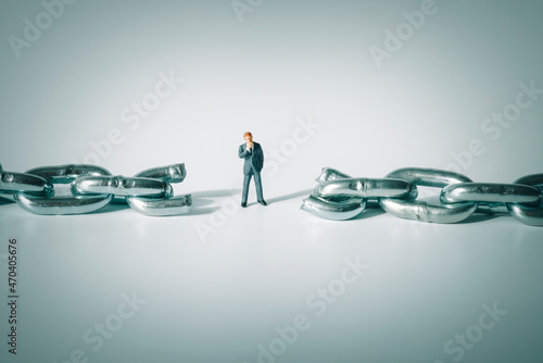 Foto Macro photo of thoughtful businessman figurine standing between broken chain