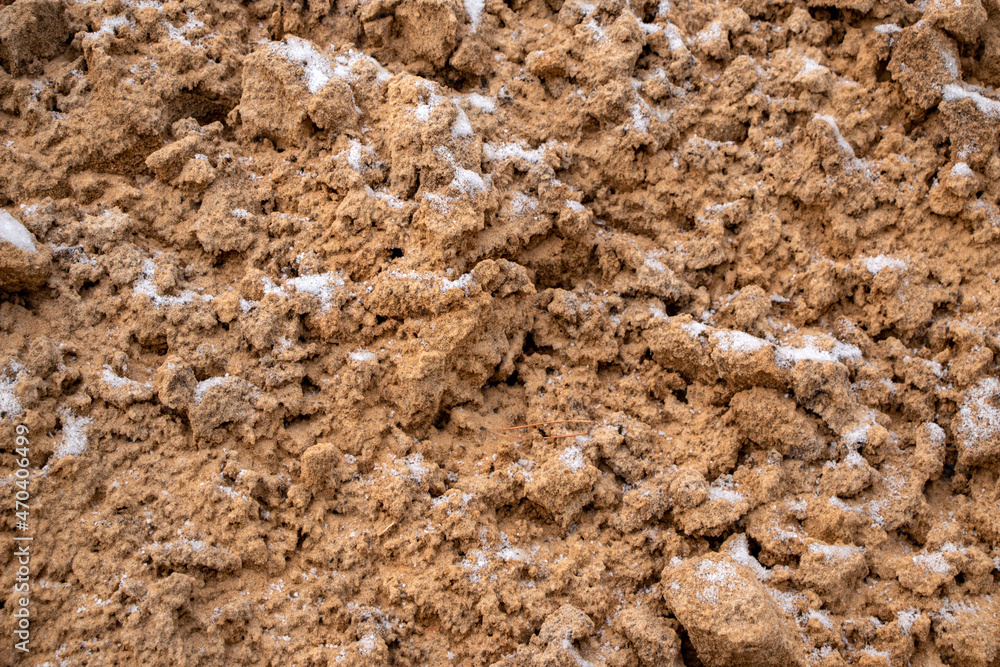 Textural sand, with relief surface, multi-colored layers and different in size of granules, in outdoor sand career, after mining ore and sand for construction. Textural sand, with relief surface, multi-colored layers and different in size of granules, in outdoor sand career, after mining ore and sand for construction.