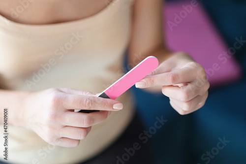 Woman holding a nail file  female hands with manicure