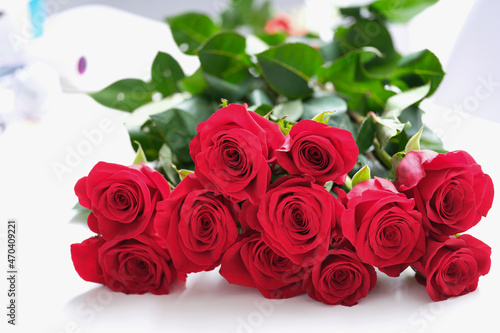 A large bouquet of red roses lies on the table