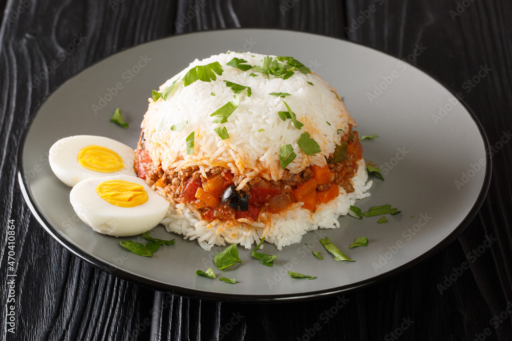 Arroz tapado is a classic Peruvian layered rice and ground beef dish close up in the plate on the table. Horizontal Arroz tapado is a classic Peruvian layered rice and ground beef dish close up in the plate on the table. Horizontal