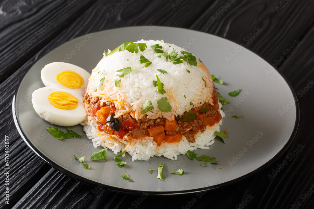 Peruvian rice with ground beef and various seasonal vegetables close-up in a plate on the table. horizontal Peruvian rice with ground beef and various seasonal vegetables close-up in a plate on the table. horizontal