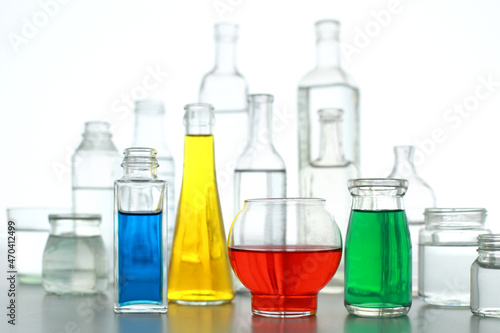 色の付いた水が入った瓶やコップ © Free1970