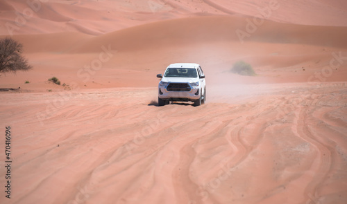 Off road vehicle driving through red desert - Namibia