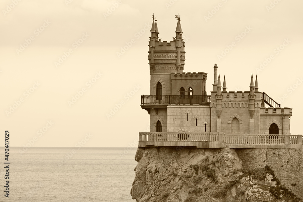 Gothic castle Swallow's Nest on a 40-meter cliff of Cape Ai-Todor above the Black Sea. The main attraction of Crimea and the symbol of Yalta town. Sepia filter, old photo style