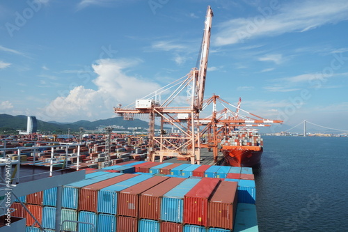  View on second largest container port in Korea, Kwangyang Port in Yeosu, south of Busan City with cargo ships and gantry cranes. In background Yi Sun-sin Bridge.   photo