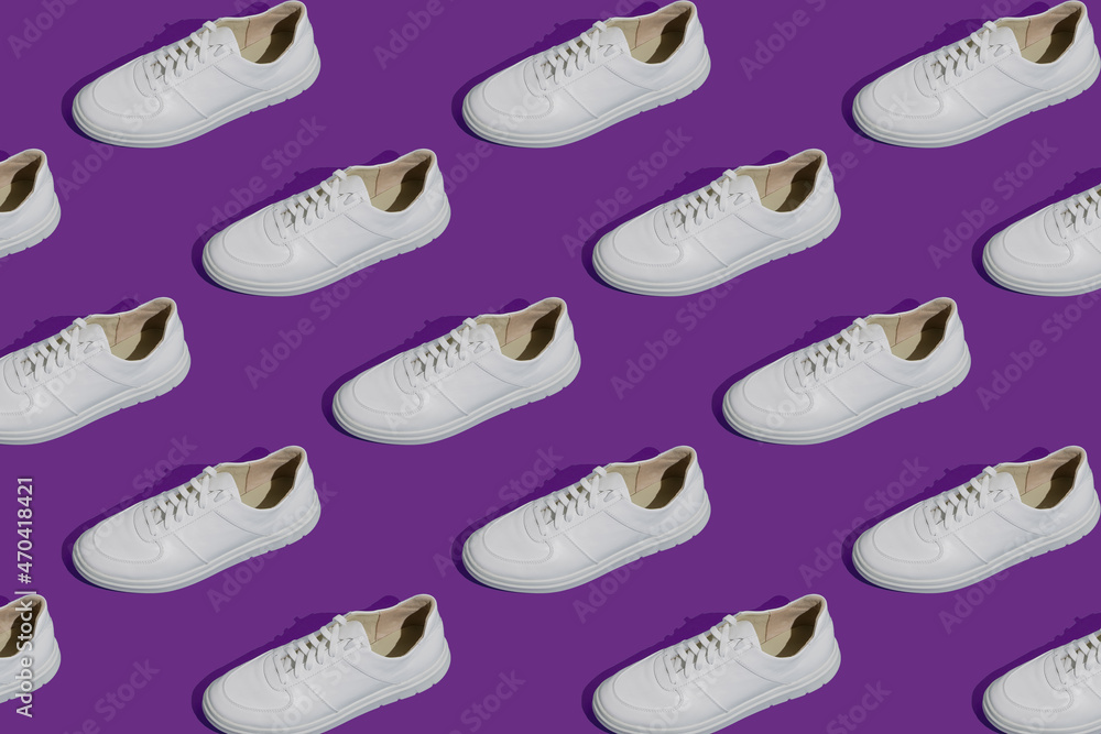 White sneakers pattern on a gray background. The shoes are comfortable and casual. Background for a shoe store. White sneakers pattern on a gray background. The shoes are comfortable and casual. Background for a shoe store.