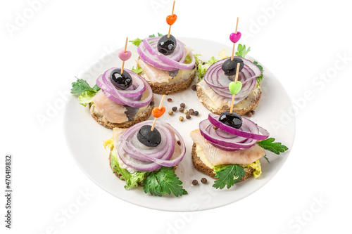 Canapes on toothpicks with herring fillet, olives and onion isolated on white background. Holiday banquet snacks