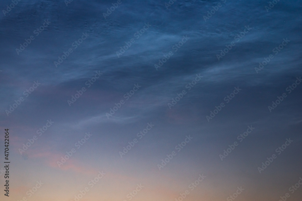 Noctilucent clouds close up on a summer night. Glowing clouds in the night sky.
