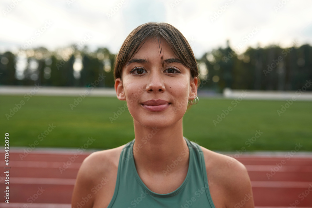 Young smiling sports woman on stadium treadmill Young smiling sports woman on stadium treadmill