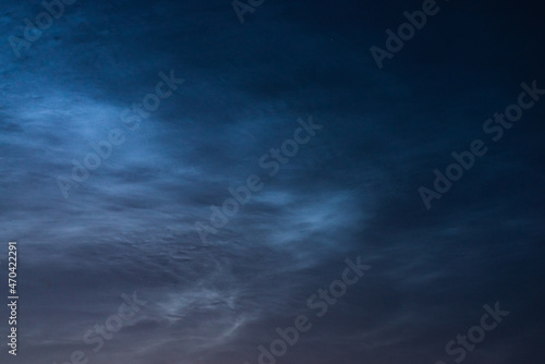 Noctilucent clouds close up on a summer night. Glowing clouds in the night sky.