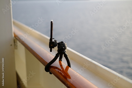 smartphone sul piccolo cavalletto ancorato ad un parapetto sul mare photo