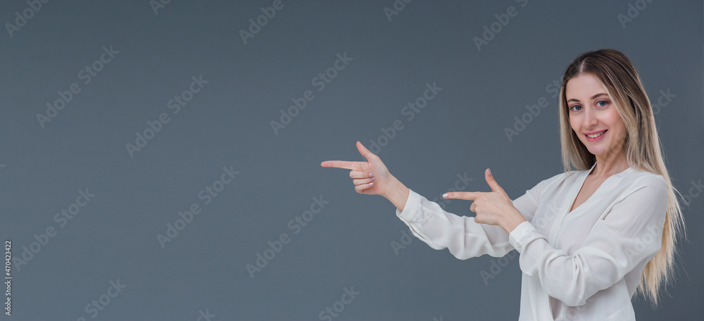 Beautiful blonde woman gesture and sign concept. She points to left side with warm smile. Includes copy space. Beautiful blonde woman gesture and sign concept. She points to left side with warm smile. Includes copy space.