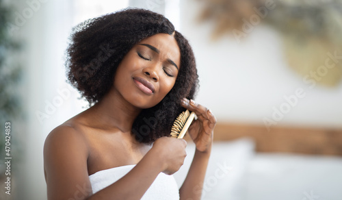 Frustrated young black lady having problem brushing her tangled hair at home, banner with copy space photo
