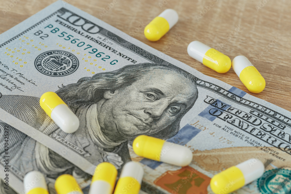 Money for drugs, a concept, 100 dollars and pills close-up Money for drugs, a concept, 100 dollars and pills close-up