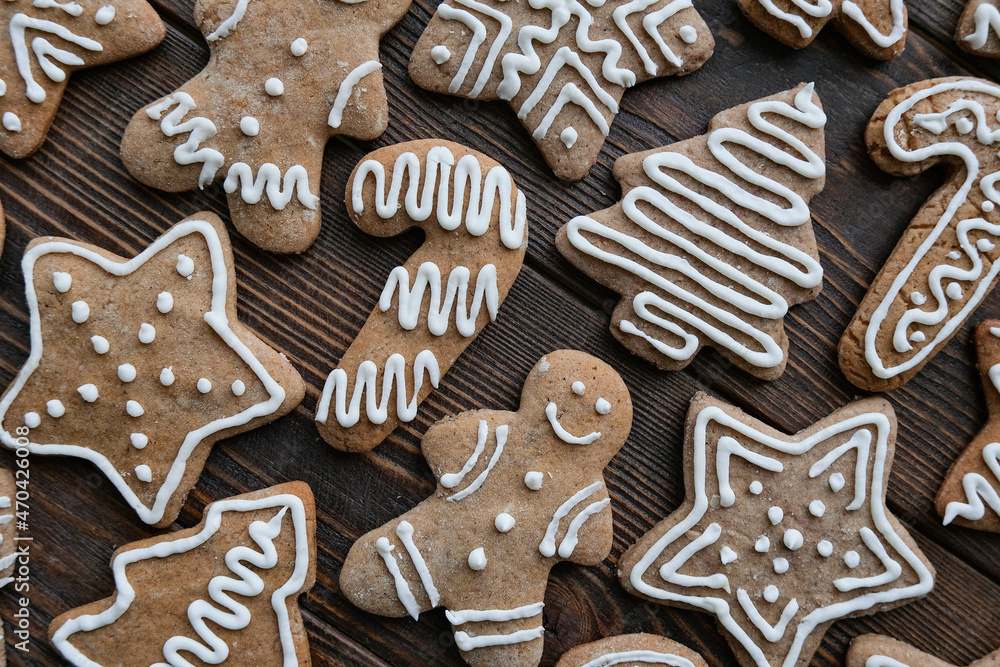 Christmas pattern with gingerbread cookies on a brown wooden texture background Christmas pattern with gingerbread cookies on a brown wooden texture background
