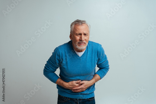 Handsome senior  isolated on grey background. Old man feeling pain. Concept about the third age and seniority