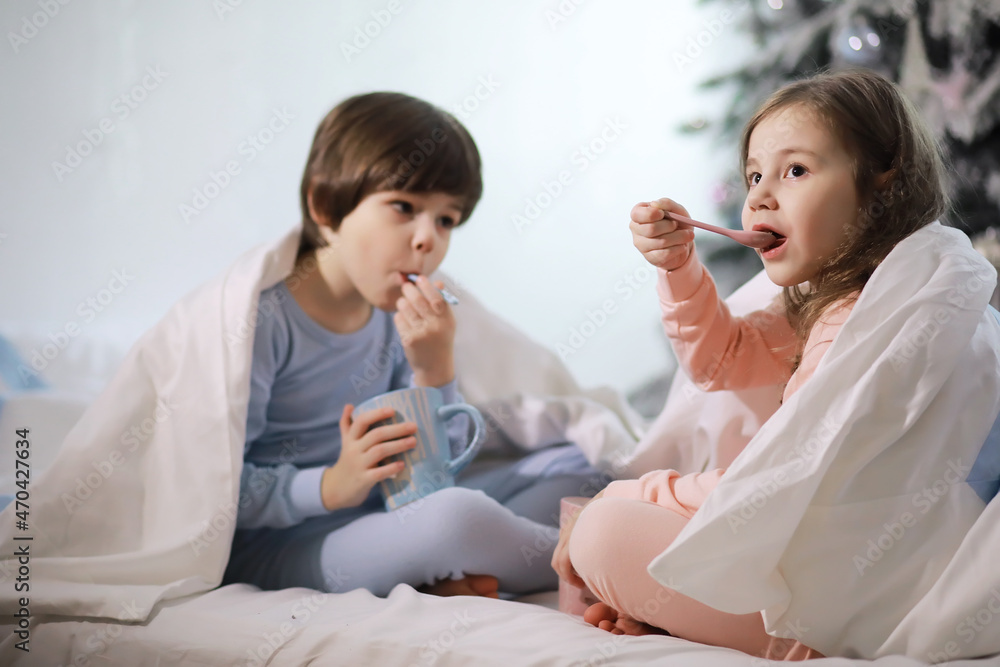 A family with children having fun on the bed under the covers during the Christmas holidays. A family with children having fun on the bed under the covers during the Christmas holidays.