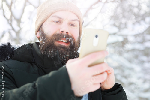 Outdoor portrait of handsome man in coat and scurf. Bearded man in the winter woods. photo