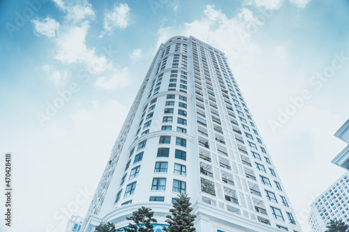 High-rise apartment buildings in the city center. Low angle shot of modern architecture in blue sky. Futuristic cityscape view 