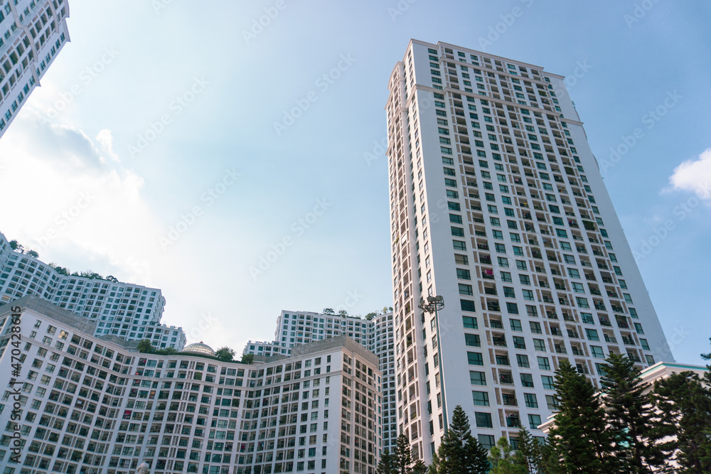 High-rise apartment buildings in the city center. Low angle shot of modern architecture in blue sky. Futuristic cityscape view 