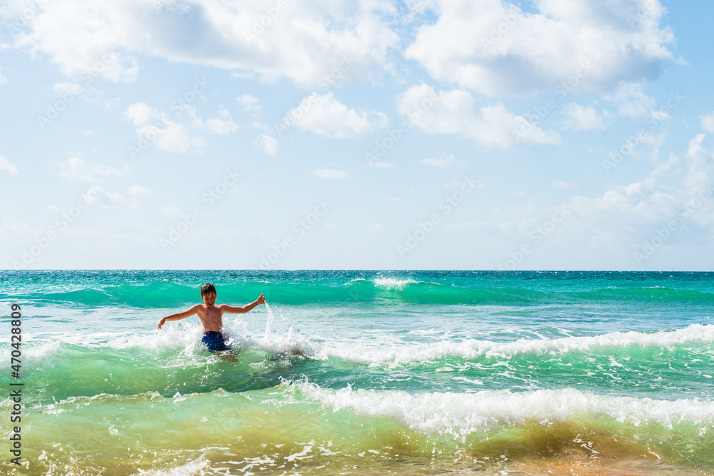 Boy with arms outstretched playing in sea, Alvor, Algarve, Portugal, Europe Boy with arms outstretched playing in sea, Alvor, Algarve, Portugal, Europe