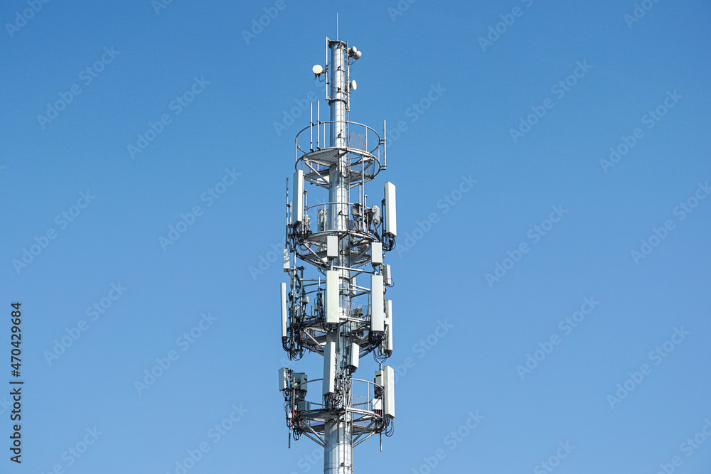 Cell phone, mobile phone telecommunication tower with antennas on blue sky