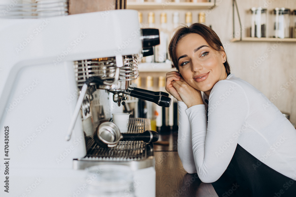 Woman barista at a coffee shop preparing coffee Woman barista at a coffee shop preparing coffee