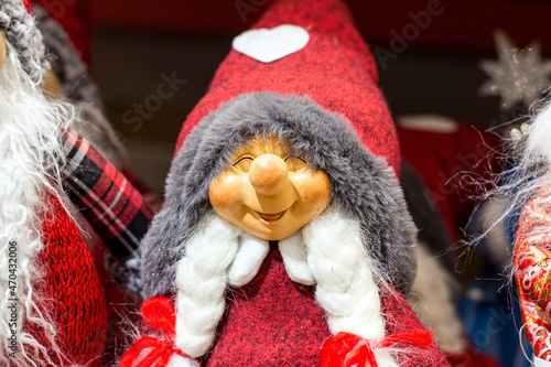 Colorful Christmas woman gnome from Nordic folklore (Nisse, Tomte, Tonttu, Tomtenisse) doll with red hat and white braids. Traditional Scandinavian Xmas and winter solstice symbol. photo