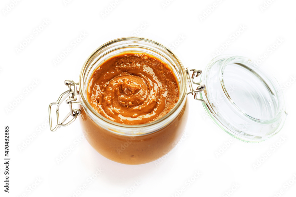 Peanut butter in a jar isolated on white background. Top view