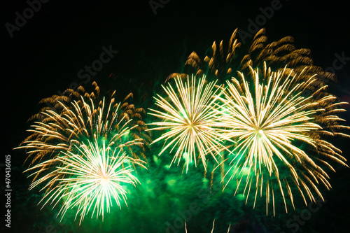 Golden green firework on black background.