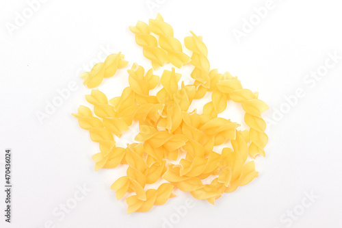 A Heap of Uncooked Fusilli Pasta Scattered on White Table. Raw and Dry Macaroni. Unhealthy and Fat Food. Italian Culture