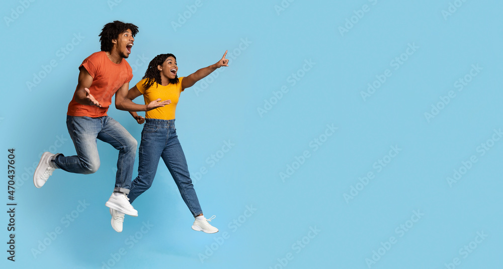 Carefree young black man and woman jumping in the air Carefree young black man and woman jumping in the air
