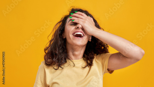 Φωτογραφία Portrait of woman with curly dark hair forgetting something, slapping forehead w