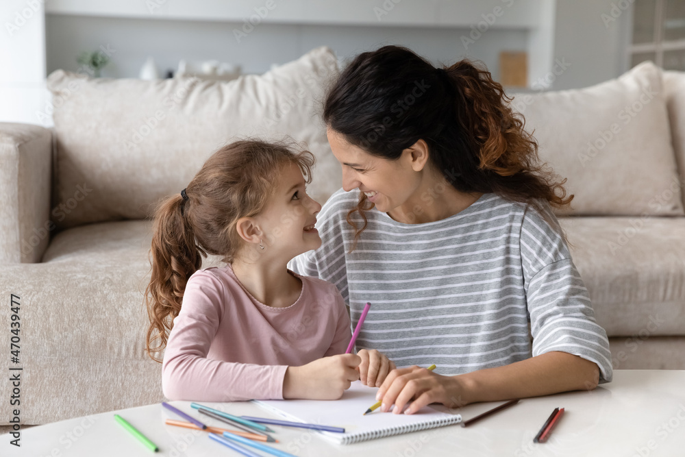 Happy mother and cute daughter drawing with colorful pencils together, engaged in educational creative activity, caring mom and little girl kid painting in album, enjoying leisure time at home Happy mother and cute daughter drawing with colorful pencils together, engaged in educational creative activity, caring mom and little girl kid painting in album, enjoying leisure time at home