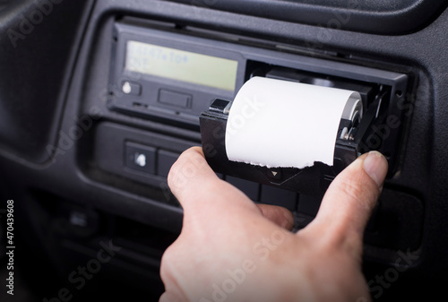 Digital tachograph with an open printer and visible roll of paper. Paper roll Replacement in a truck digital tachograph