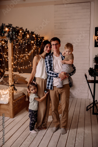 Beautiful young family near a Christmas tree on Christmas Eve