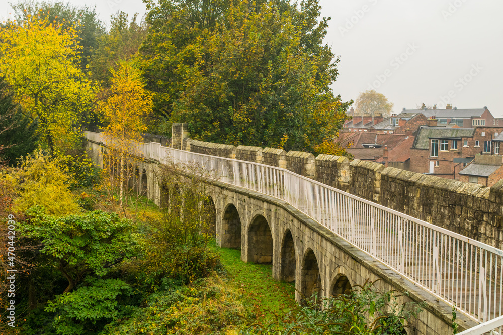 Fototapeta premium Arches under the trail on top of medieval 13th century city wall with view of the town of York in England