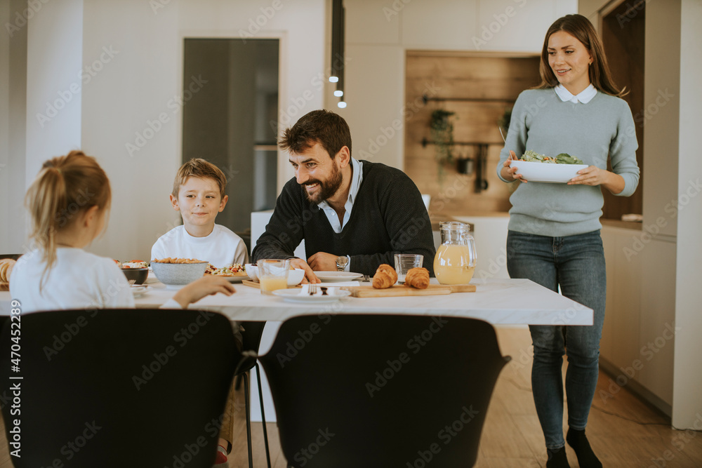 Young mother preparing breakfast for her family in the kitchen Young mother preparing breakfast for her family in the kitchen
