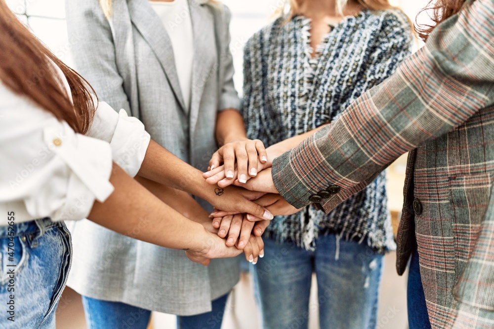 Group of young businesswoman standing with hands together at the office. Group of young businesswoman standing with hands together at the office.