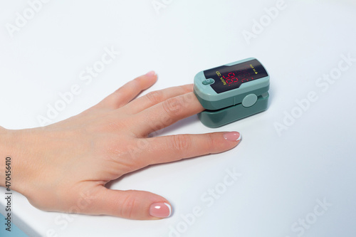 Close up shot of patient hand with pulse oximeter attached to finger for monitoring of saturation in the hospital