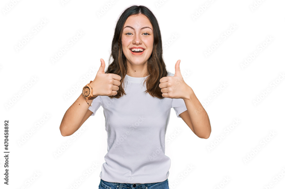 Young beautiful woman wearing casual white t shirt success sign doing positive gesture with hand, thumbs up smiling and happy. cheerful expression and winner gesture. Young beautiful woman wearing casual white t shirt success sign doing positive gesture with hand, thumbs up smiling and happy. cheerful expression and winner gesture.