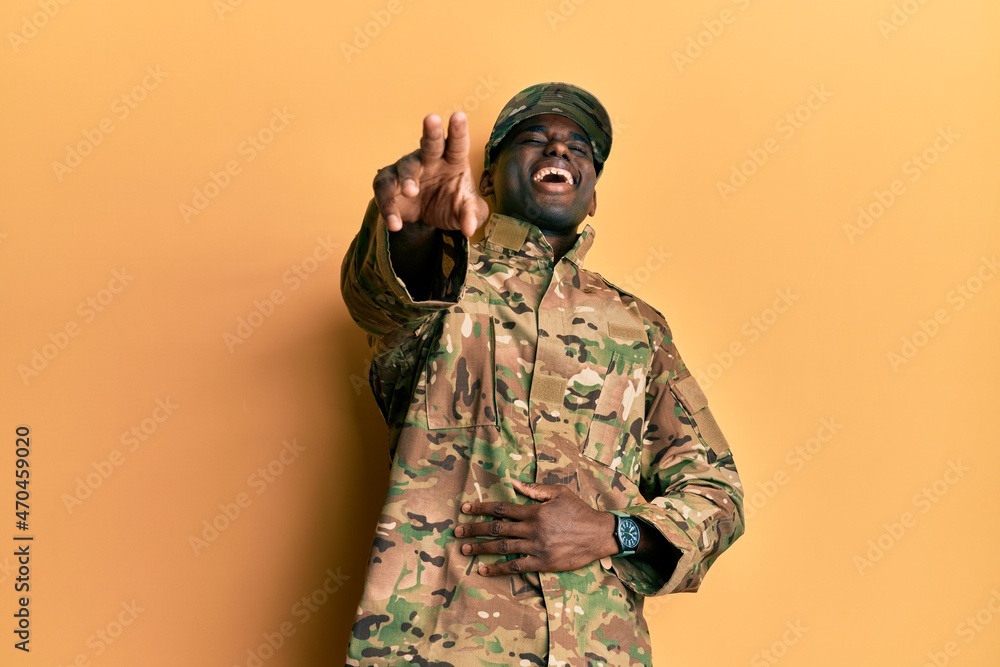 Young african american man wearing army uniform laughing at you, pointing finger to the camera with hand over body, shame expression Young african american man wearing army uniform laughing at you, pointing finger to the camera with hand over body, shame expression
