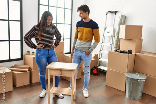 Obraz na plátně Young latin couple smiling happy assembling piece of furniture at new home
