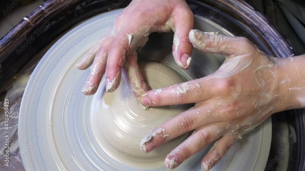 the hands of a potter's apprentice are trying to make a cup from a clay blank on a potter's wheel the hands of a potter's apprentice are trying to make a cup from a clay blank on a potter's wheel