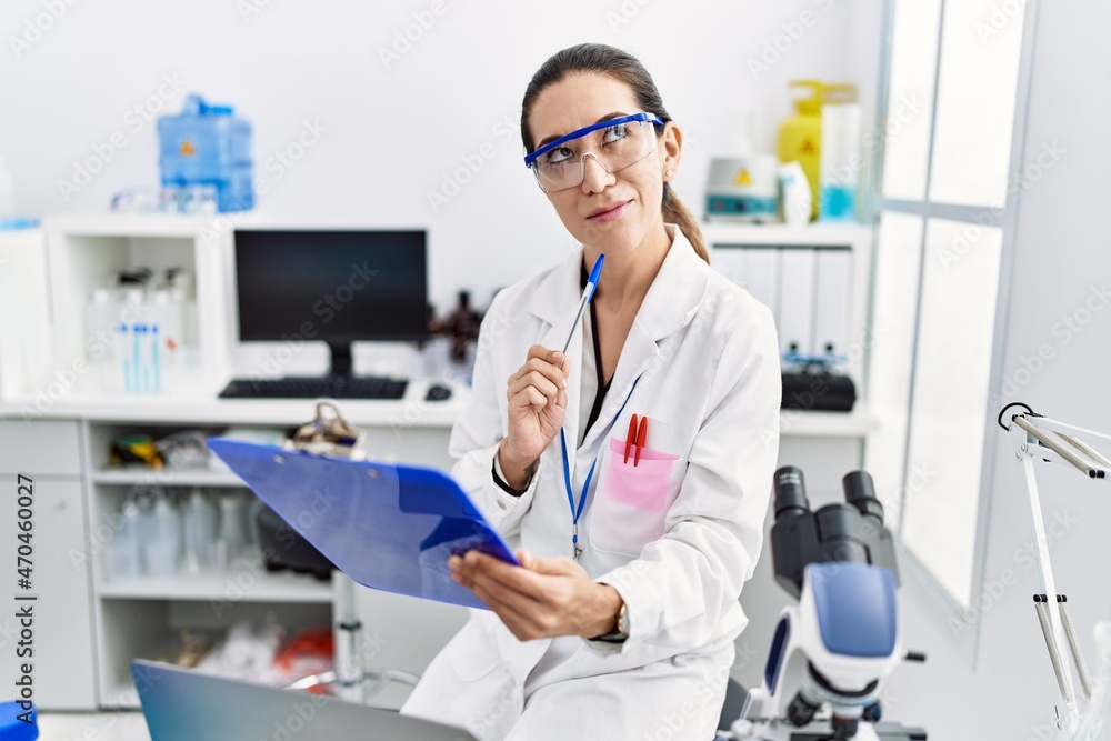 Young hispanic woman wearing scientist uniform working at laboratory Young hispanic woman wearing scientist uniform working at laboratory