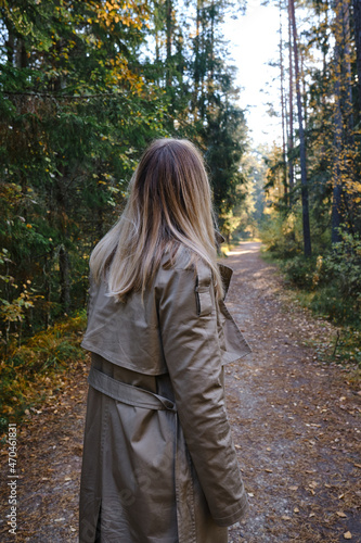 A woman traveler walks through the forest. Beautiful nature landscape in woods. Hiking journey on tourist trail. Outdoor adventure. Travel and exploration. Healthy lifestyle, leisure activities © Iuliia Pilipeichenko